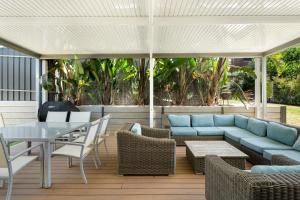 a patio with a blue couch and a table and chairs at The Sandbar Stay - Wi-Fi, BBQ, Parking in Middleton
