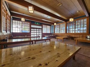 a large room with wooden tables and windows at Tokiwa-Tei in Hakuba
