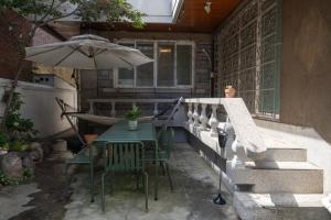 a table and chairs with an umbrella on a patio at Manoa Garden in Seoul