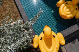 a swimming pool with yellow inflatable rubber animals on it at Villa Abigail Chiang Mai in Chiang Mai