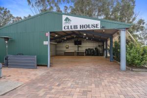 a large green building with a club house at Crows Nest Tourist Park in Crows Nest