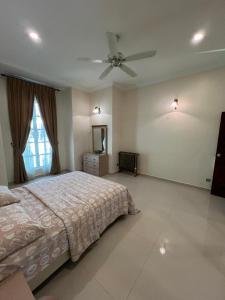 a bedroom with a bed and a ceiling fan at D'Kiara Villa in Kangar