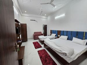 a room with two beds and a chair in it at Kharari Inn in Ayodhya