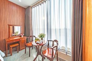 Una habitación con una mesa y sillas y una ventana. en Venus Hotel, en Ho Chi Minh