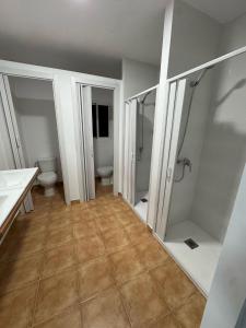 une salle de bain avec deux toilettes, un lavabo et des miroirs dans l'établissement Apartamento de habitaciones privadas en el centro de Málaga, à Malaga