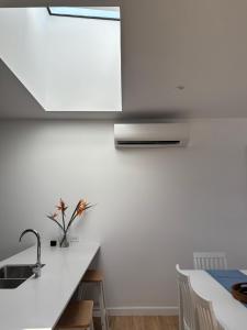 a white kitchen with a sink and a counter at The Arthur Apartments in Coffs Harbour