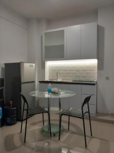 a kitchen with a table and two chairs and a refrigerator at Kos C177 in Bandung