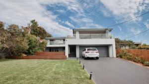 a white van parked in the driveway of a house at The Pool House - Light and Spacious in Wamberal