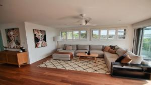 a living room with a couch and a table at The Pool House - Light and Spacious in Wamberal