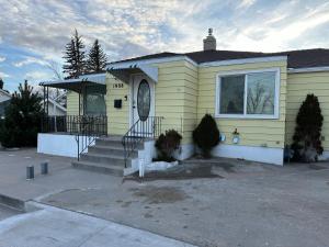 a yellow house with a staircase in front of it at 2BR Gem: Modern Comfort & Style in Cheyenne