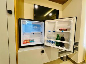 an open refrigerator with its door open and drinks inside at Hotel Sunlight in Pondicherry