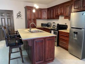 eine Küche mit Holzschränken und einem Edelstahlkühlschrank in der Unterkunft Casa Miguel Hidalgo 6 Bedroom, 4 Bath for 20 people in Puerto Peñasco