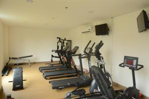 a gym with several treadms and cardio machines at Nice and Elegant Studio at Tree Park City BSD Apartment By Travelio in Tangerang