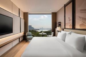ハノイにあるDusit Le Palais Tu Hoa Hanoiの大型ベッドとテレビが備わるホテルルームです。