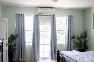 a bedroom with blue curtains and a large window at Villa jaden #2 in Road Town