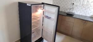 a refrigerator with its door open in a kitchen at "Ambi's stay " A unique and Secluded Nest with serene calmness views on a Traffic-Free Street at Bommasandra 3 km from Narayana Hrudayalaya Hospital in Bangalore +43 photos