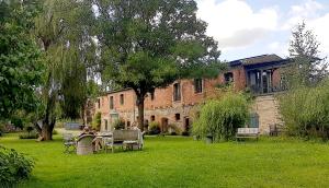 a woman sitting on a bench in front of a building at Hotel garni Hof Wetzenow in Rossow