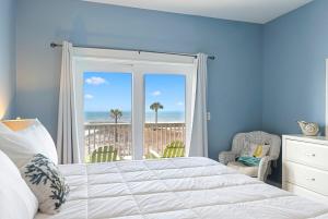 a bedroom with a bed and a view of the ocean at Cape Ocean Front - Jacuzzi - Elevator - Arcade Games! in Port Saint Joe