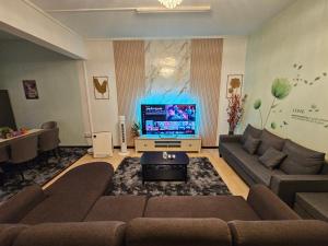 a living room with a couch and a television at Arlyn's Homestay in Sandakan