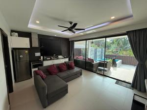 a living room with a couch and a ceiling fan at Orchid Pool Villas - Koh Chang in Ko Chang