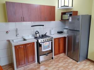 a kitchen with a stove and a refrigerator at Habich Apartment in Lima