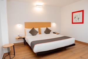a bedroom with a large bed in a room at Magnum Resorts Candolim in Candolim +63 photos