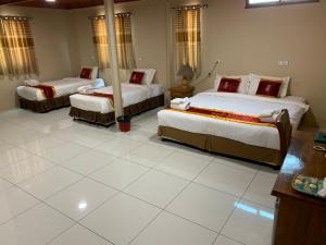 a bedroom with three beds in a room at Bagan Comfort Hotel in Bagan +33 photos