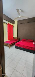 a bedroom with two beds with red sheets and a ceiling at Homestay Nilai, Airport KLIA and KLIA2 in Nilai