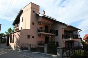 un grand bâtiment avec une clôture devant lui dans l'établissement Vila Prica, à Niška Banja