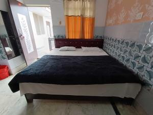 a bedroom with a large bed in a room at Hotel O Home Shri Hari Lodge Homestay in Ayodhya