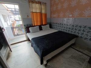 a bedroom with a bed in a room with a window at Hotel O Home Shri Hari Lodge Homestay in Ayodhya