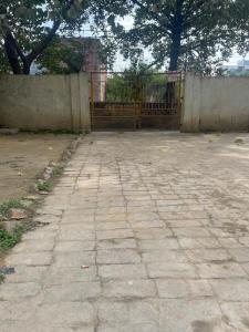 a stone courtyard with a gate and a fence at Yadav multi in Prayagraj