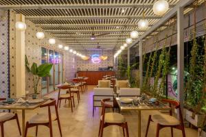 a restaurant with tables and chairs and plants at Arambhaya Boutique Hotel in Kandy