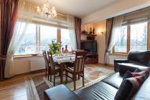 sala de estar con mesa, sillas y sofá en VIP Apartamenty Jagiellonska 33a, en Zakopane