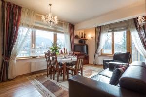 a living room with a couch and a table and chairs at VIP Apartamenty Jagiellonska 33a in Zakopane