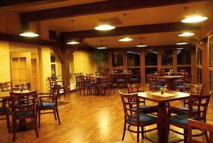 a restaurant with wooden tables and chairs and tablesearcher at Hotel Emeran in Litvínov
