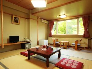 a living room with a coffee table and a television at Hotel Sunny Valley in Otari