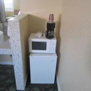 a microwave sitting on top of a refrigerator at Pacific Best Inn in Seaside