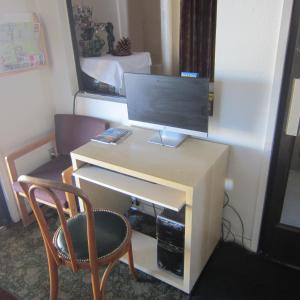 a desk with a monitor and a chair in a room at Pacific Best Inn in Seaside