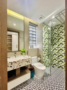 a bathroom with a toilet and a sink and a shower at Luxury Sunset Town Hotel Phu Quoc in Phu Quoc