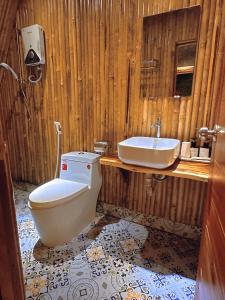 a wooden bathroom with a toilet and a sink at Waikiki Lagi Beach homestay & restaurant in La Gi