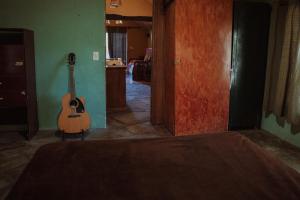 グアズビラにあるCasa del Bosque a pasos del Marの廊下に座るギター +13枚の写真