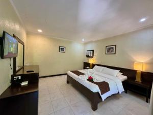 a hotel room with a bed and a television at Casa Pilar Beach Resort in Boracay