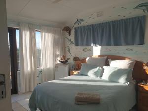 a bedroom with a large bed with birds on the wall at Deep Blue Guest House in Amanzimtoti