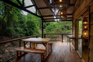 una terraza de madera con mesa y bancos. en Matumi Trail Forest Lodges - Matumi and Mitzeeri, en Tzaneen