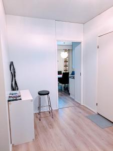 a room with white walls and a table and a stool at Spacious Northern City Apartment in Rovaniemi