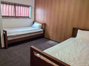 a small room with two beds and a window at ホステル今鶴 二人部屋 402号室 in Osaka