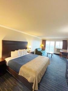 a hotel room with a large bed and a desk at Coratel Inn Ocean Shores Extended Stay in Ocean Shores