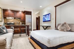 a bedroom with a large bed and a kitchen at LMV A-107 in Park City