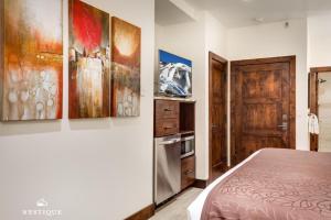 a bedroom with a bed and some paintings on the wall at LMV A-107 in Park City +18 photos
